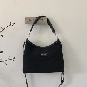 Detail of black matte shoulder bag with Lazy Breeze brand patch and adjustable strap