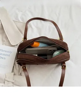 Interior espacioso del bolso de gamuza marrón que muestra gran capacidad para esenciales