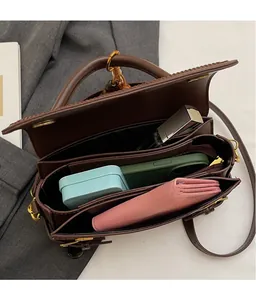 Top view of deep brown leather bag showing two main compartments and middle zip pocket