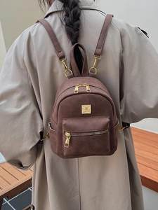 Brown vintage faux suede backpack for women with gold zippers shown on a model