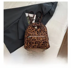 Détail du sac à dos en velours léopard avec pendentif en métal en forme de cœur et nœud