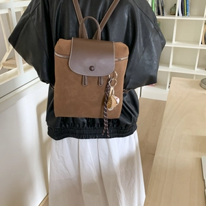 Vista posteriore di uno zaino vintage marrone con dettagli intrecciati sulla schiena di un modello