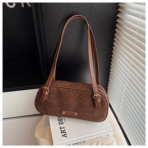 Detailed close-up of dark brown suede Boston bag with gold logo and fine stitching