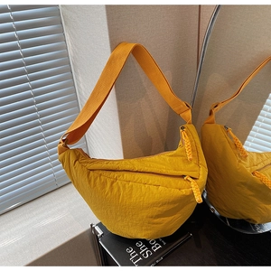 Dettaglio della borsa a mezzaluna gialla in nylon con tracolla larga regolabile