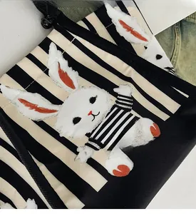 Dettaglio di una borsa tote in tela a righe con una simpatica stampa di un coniglio