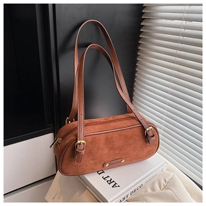 Close-up of caramel brown retro Boston bag with metal plate on artistic photo book