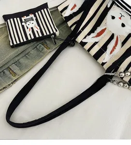 Dettaglio del set di borse in tela a righe con motivo a coniglio e piccola pochette