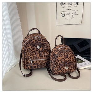 Détail de mini sacs à dos en velours léopard avec bretelles cuir et pendentif cœur
