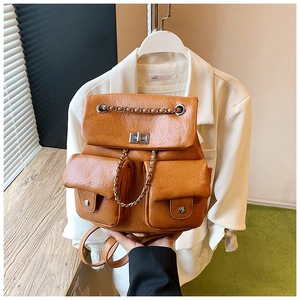 Detail of caramel faux leather backpack with lychee texture and silver chain strap
