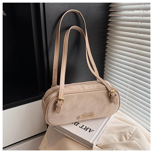 Detailed texture of beige suede Boston bag with gold metal logo and slim leather straps