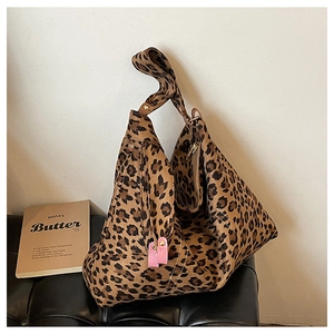 Detailed view of leopard print tote bag with wide strap on black bench for casual daily use