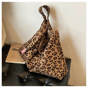 Detail of leopard print tote featuring unique single knotted handle and pink leather buckle