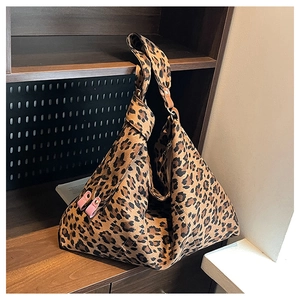 Detail of leopard print tote bag with pink leather trim and wide shoulder strap