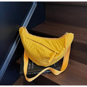 Dettaglio della borsa a mezzaluna gialla in nylon con texture a pieghe e zip a corda