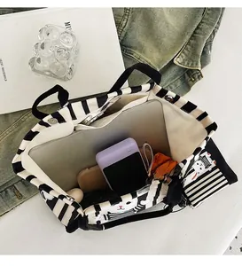 Dettaglio interno della borsa tote a righe con capienza per laptop e accessori