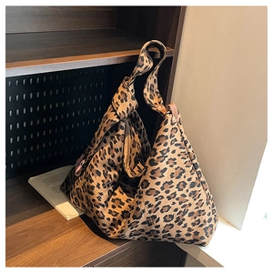 Detail of soft leopard print tote bag featuring a unique knotted shoulder strap design