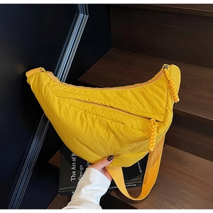 Dettaglio borsa a mezzaluna giallo acceso con trama in nylon e tirazip intrecciati