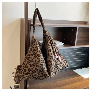 Detail of leopard print tote bag with pink zipper pulls and decorative stitching