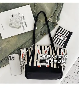 Dettaglio borsa tote grande in tela a righe con patch a coniglio e astuccio