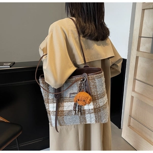 Large checkered wool tote bag with leather straps and plush toy charm on model