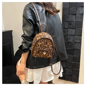 Détail d'un mini sac à dos léopard avec bordure en cuir et pendentif en cœur
