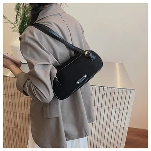 Detailed back view of a black Boston shoulder bag with gold hardware and logo on model