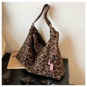 Detail of leopard print hobo bag showing knotted shoulder strap and textured fabric