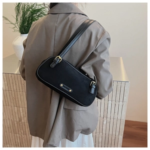 Minimalist black leather underarm bag with gold buckle styled with grey office blazer