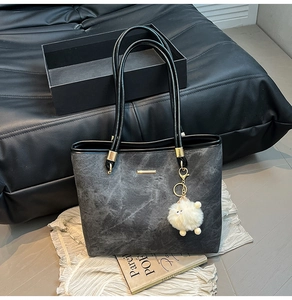 Detailed macro view of dark grey marble texture tote bag with golden metal hardware