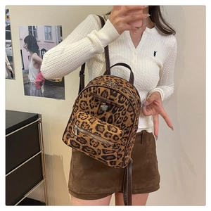 Détail du mini sac à dos en velours léopard avec nœud et pendentif cœur argenté