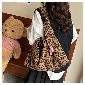 Detailed view of leopard print tote bag with pink leather trim and white stitching decor