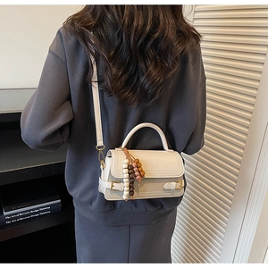 Model wearing retro cream white crossbody square bag with stylish wooden bead charm