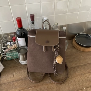Dettaglio dello zaino vintage marrone opaco con patta in pelle e fibbia decorativa