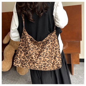 Macro shot of large leopard print tote bag fabric texture and adjustable shoulder strap