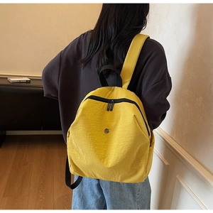 Vista posteriore di una modella che indossa lo zaino in nylon giallo brillante