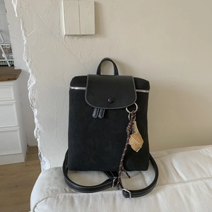 Dettaglio dello zaino vintage nero con cuciture in pelle scamosciata opaca a contrasto