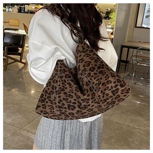 Detail of leopard print faux suede tote bag with white double stitching and crescent shape