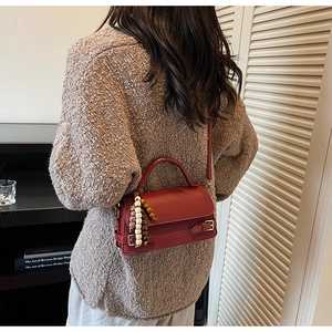 Close-up of vintage burgundy handbag with fine texture and beaded tassel detail