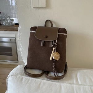Dettaglio dello zaino vintage in pelle scamosciata marrone con patta in pelle