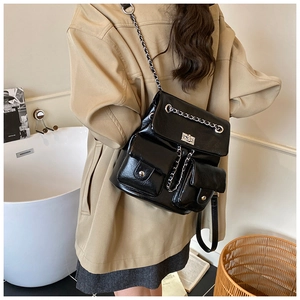 Back view of model wearing a black glossy chain backpack with silver twist locks
