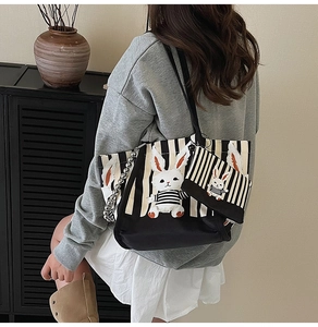 Dettaglio della borsa in tela a righe con patch coniglio e mini pochette coordinata