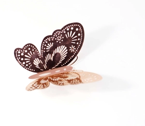Macro shot of 3D laser-cut butterfly wall sticker in rose gold with intricate patterns