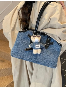 Chic blue denim tote bag with black leather trim and cute white teddy bear charm