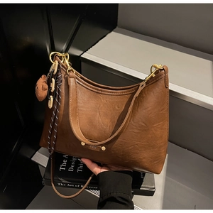 Retro brown PU leather tote with plush bear charm and stylish chain detail closeup