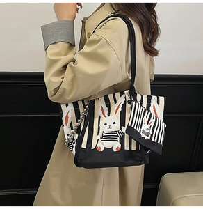Dettaglio della borsa tote in tela a righe con disegno di coniglio e mini pochette