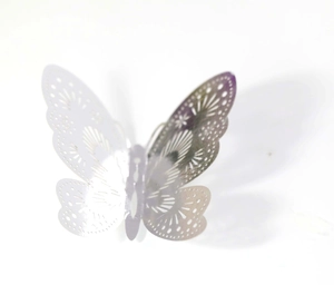 Macro detail of 3D metallic butterfly wall sticker with intricate cutout patterns