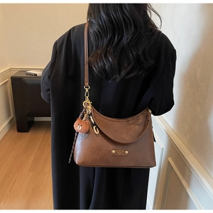 Detailed shot of retro brown hobo bag with teddy charm and acrylic chain strap