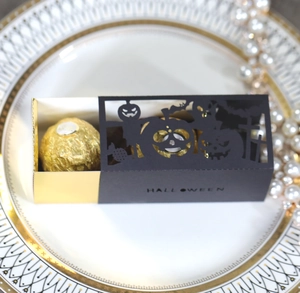 Detail of laser-cut Halloween gift box featuring black bat patterns and gold inner drawer