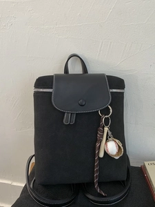 Zaino vintage nero opaco minimalista con cuciture bianche e ciondolo da baseball