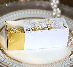 Detail of laser-cut snowflake Christmas candy box with elegant white and gold hollow pattern